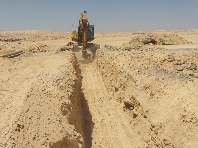 حفار يشق خندقًا بمحاذاة الطريق