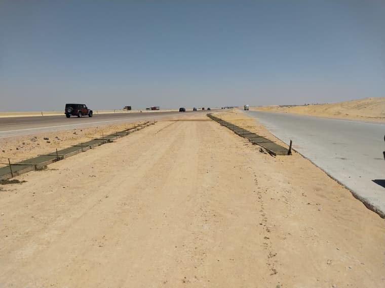ممر ترابي قيد التنفيذ بمحاذاة طريق أسفلتي مفتوح للمرور