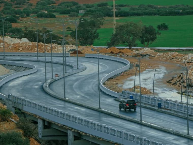 لقطة علوية لتقاطع طرق وكوبري منحنٍ بين أراضٍ زراعية